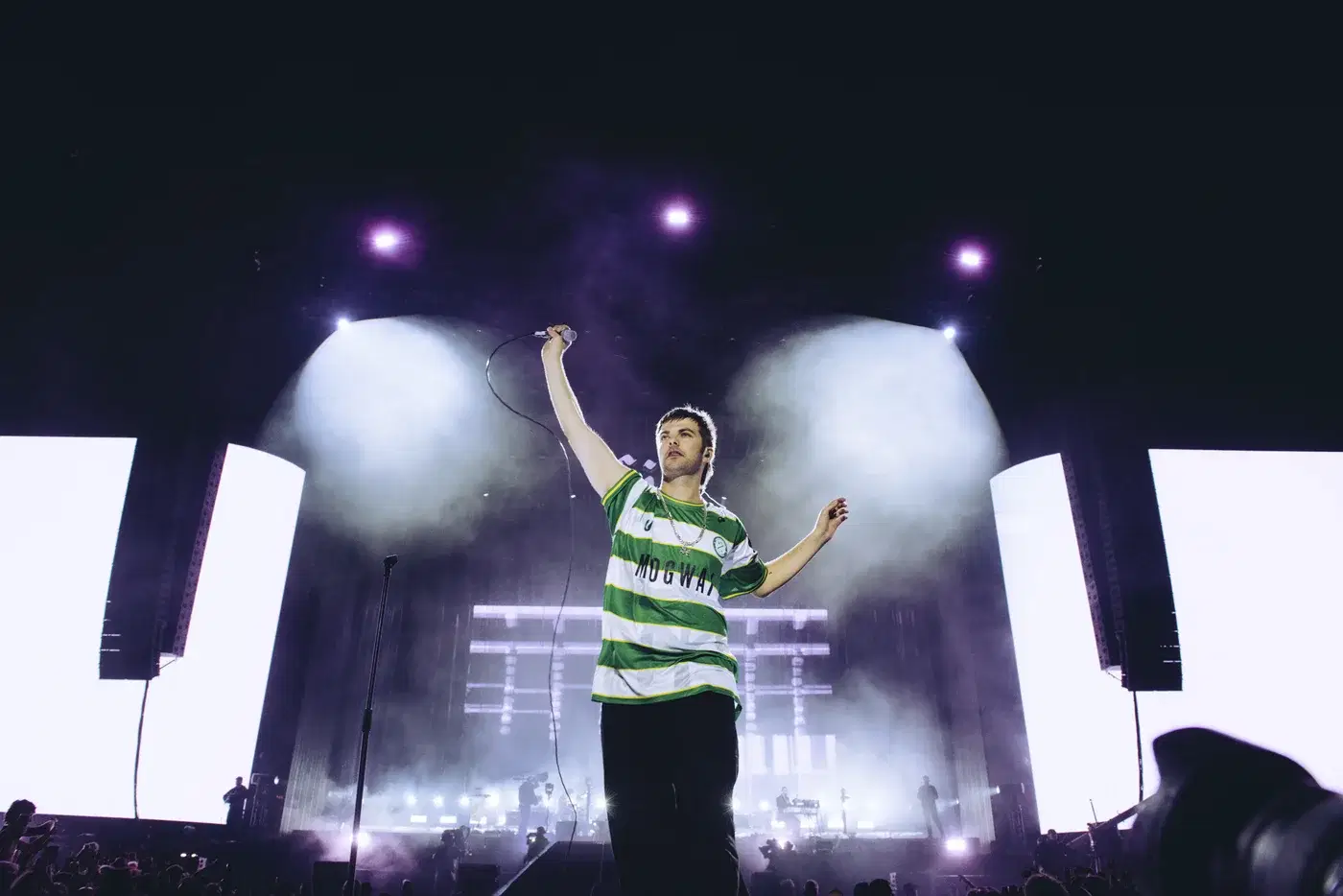 Grian Chatten of Fontaines D.C. in the Cwmbran Celtic Mogwai shirt under white stage lights at Reading Festival