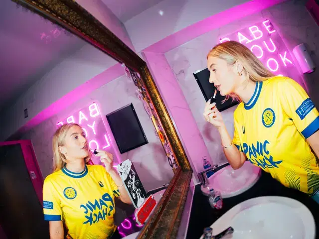 Models at the mirror in the neon-lit toilets at Le Pub