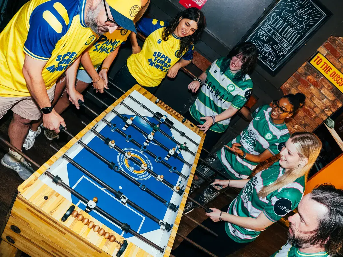 Four models around the foosball table at Le Pub