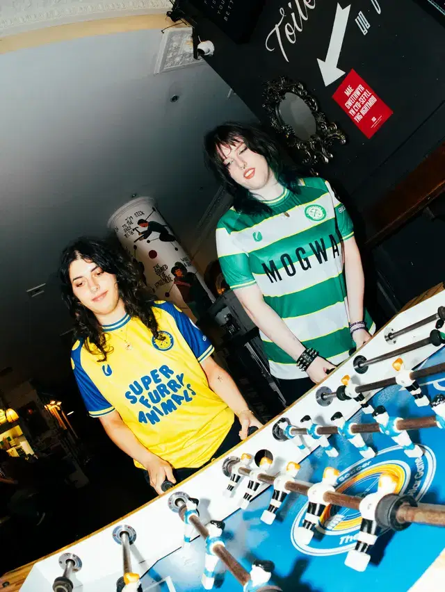 Models playing foosball in the Super Furry Animals and Mogwai shirts