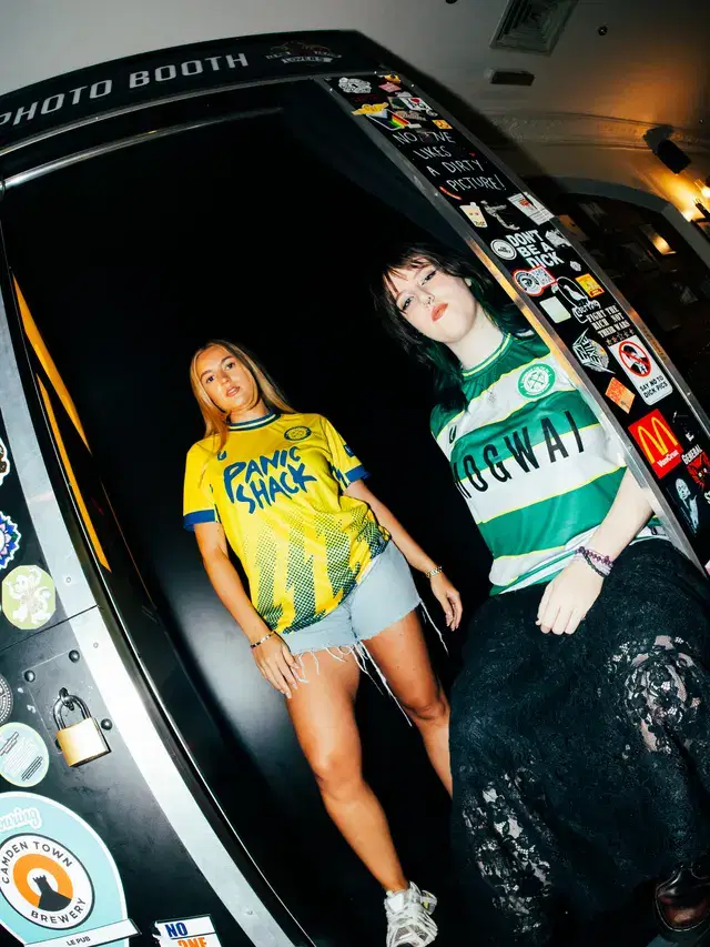 Models beside the sticker-covered photo booth at Le Pub
