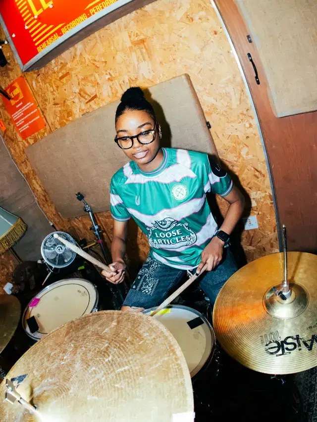 Model on the drums in the Loose Articles shirt
